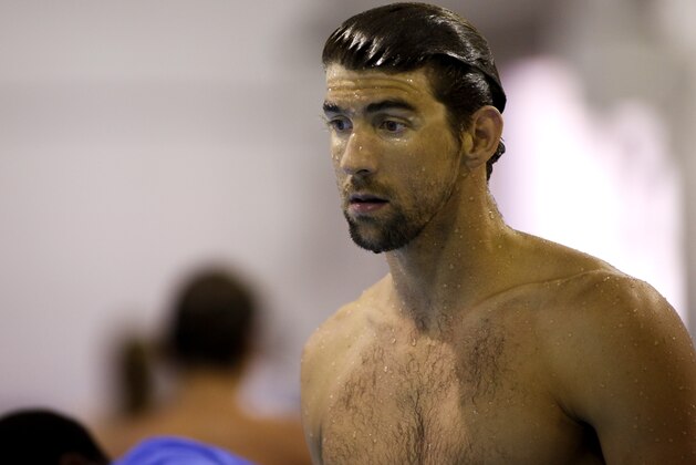 Michael Phelps stands poolside after practicing at the Arena Pro Swim Series swim meet in Charlotte, N.C, Thursday, May 14, 2015. (AP Photo/Nell Redmond)