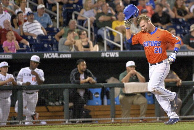 Florida first baseman Peter Alonso (20) runs past the Miami dugout while running the bases on a two-run home run in the seventh inning of an NCAA College World Series baseball elimination game at TD Ameritrade Park in Omaha, Neb., Wednesday, June 17, 2015. (AP Photo/Ted Kirk)