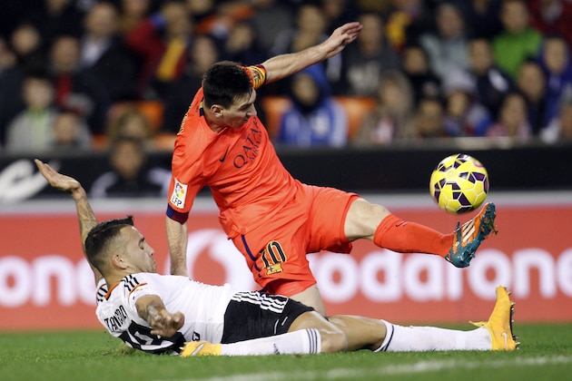 Barcelona's Lionel Messi, from Argentina, top, duels for the ball with Valencia's Otamendi  during a Spanish La Liga soccer match at the Mestalla stadium in Valencia, Spain, on Sunday, Nov. 30, 2014.(AP Photo/Alberto Saiz)
