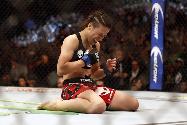 Mar 14, 2015; Dallas, TX, USA;  Joanna Jedrzejczyk (blue) celebrates defeating Carla Esparza (red) in the women's strawweight title bout during UFC 185 at American Airlines Center. Mandatory Credit: Tim Heitman-USA TODAY Sports
