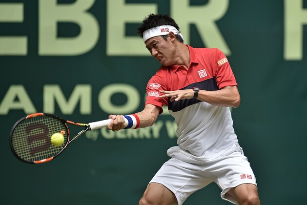 Kei Nishikori of Japan returns the ball to Dustin Brown from Germany during their second round match at the Gerry Weber Open ATP tennis tournament in Halle, Germany, Thursday, June 18, 2015. (AP Photo/Martin Meissner)