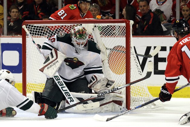 Minnesota Wild goalie Devan Dubnyk, left, can't make a save a goal hit by Chicago Blackhawks center Jonathan Toews, right, during the second period  of Game 2 in the second round of the NHL Stanley Cup hockey playoffs in Chicago, Sunday, May 3, 2015. (AP Photo/Nam Y. Huh)