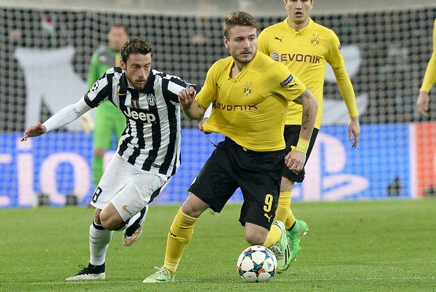 Borussia Dortmund' Ciro Immobile, right, challenges the ball with Juventus' Claudio Marchisio, left, during the Champions League round of 16 first leg soccer match between Juventus and Borussia Dortmund at the Juventus Stadium, in Turin, Italy, Tuesday, Feb. 24, 2015. (AP Photo/ Massimo Pinca)