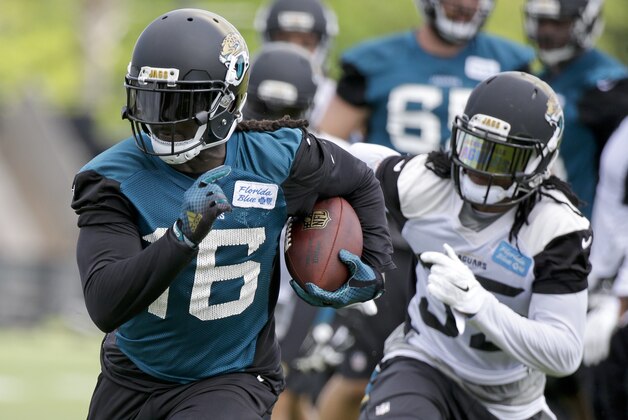 Jacksonville Jaguars running back Denard Robinson (16) carries the ball past cornerback Demetrius McCray, right, during NFL football organized training activities, Tuesday, May 26, 2015, in Jacksonville, Fla. (AP Photo/John Raoux)