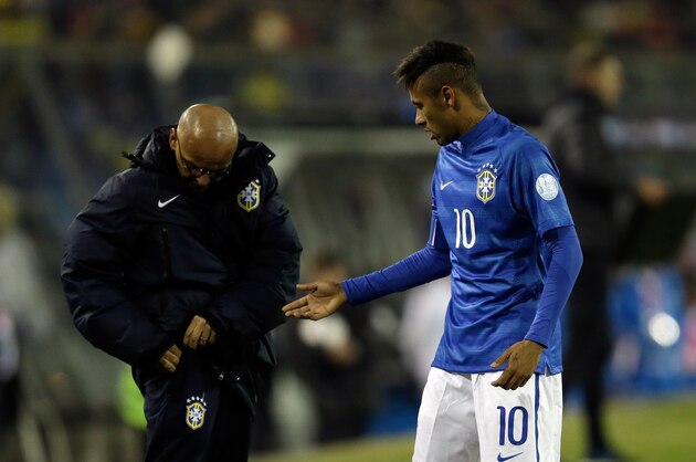 Brazil's Neymar gets a tissue from a team staff member to block his bleeding nose during a Copa America Group C soccer match against Colombia at the Monumental stadium in Santiago, Chile, Wednesday, June 17, 2015. (AP Photo/Natacha Pisarenko)
