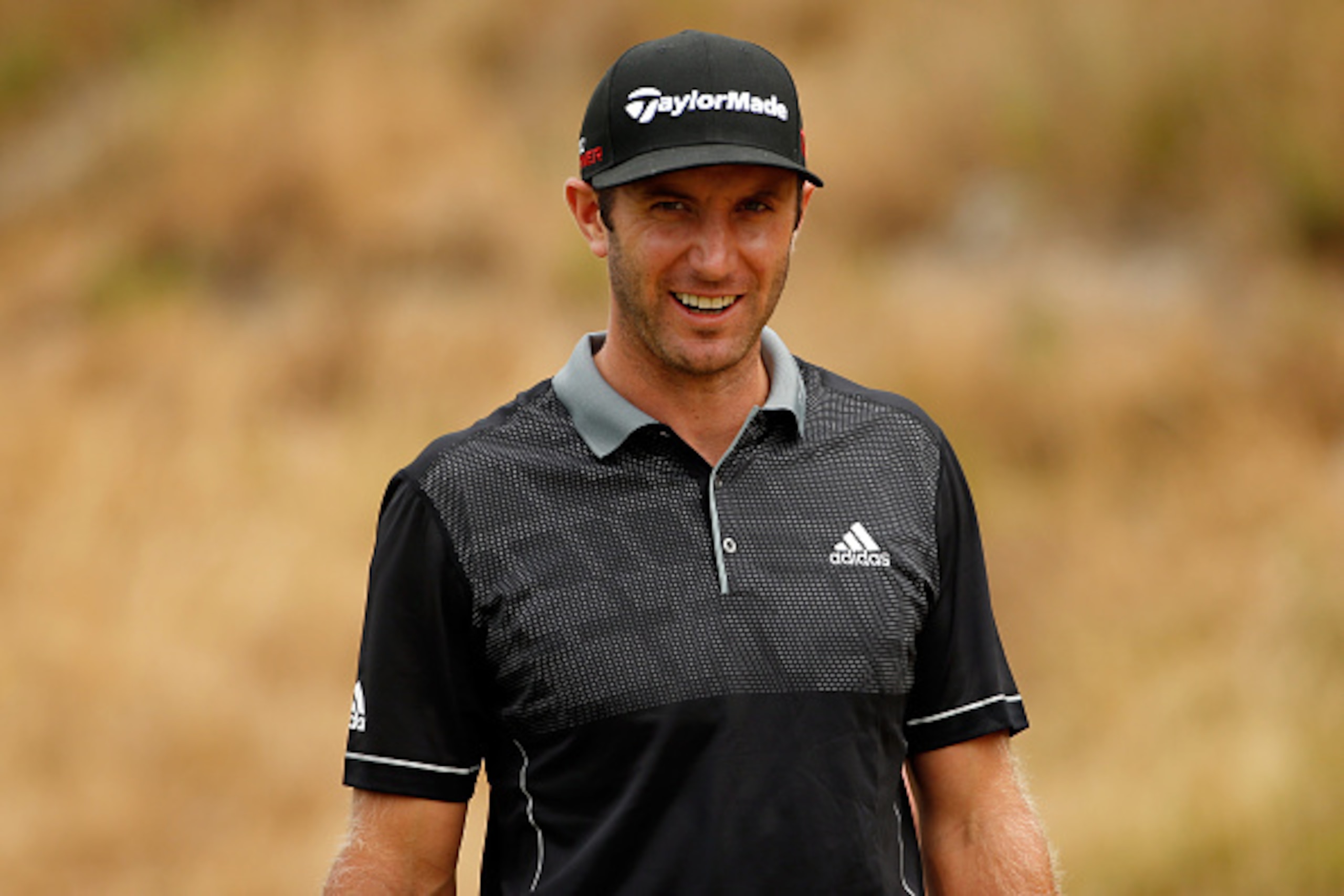 UNIVERSITY PLACE, WA - JUNE 18:  Dustin Johnson of the United States smiles after he walks off the eighth hole tee during the first round of the 115th U.S. Open Championship at Chambers Bay on June 18, 2015 in University Place, Washington.  (Photo by Ezra Shaw/Getty Images)