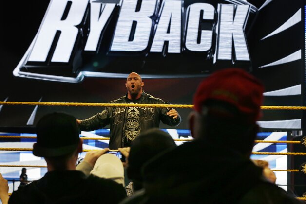 People gather ringside as they listen to professional wrestler Ryan Reeves, known as Ryback, at the Wrestlemania Axxess event Saturday, April 6, 2013, in East Rutherford, N.J., ahead of Sunday's WWE Wrestlemania 29 at MetLife stadium. (AP Photo/Mel Evans)