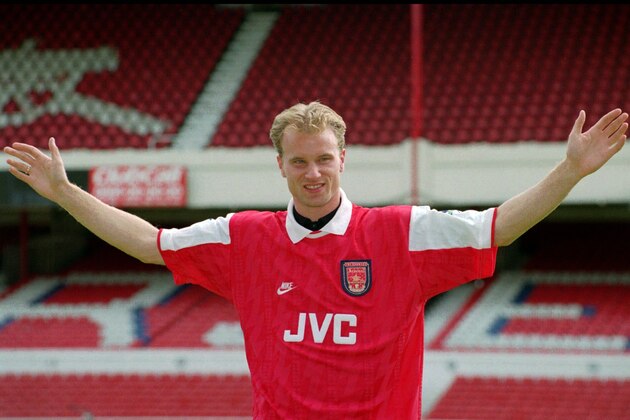 Dutch striker Dennis Bergkamp displays his Arsenal shirt, on the pitch at Highbury Stadium in London, Tuesday June 20, 1995, after joining Arsenal from the Italian club Inter Milan, in a 7.5 million Pound (US$ 12 million) deal. Details of the four-year deal were not announced, but newspapers reported that Bergkamp, 26, who has scored 23 goals in 39 international appearances for the th Netherlands, will be paid 25,000 Pounds (US$ 40,000) a week.(AP Photo/Charles Miller)