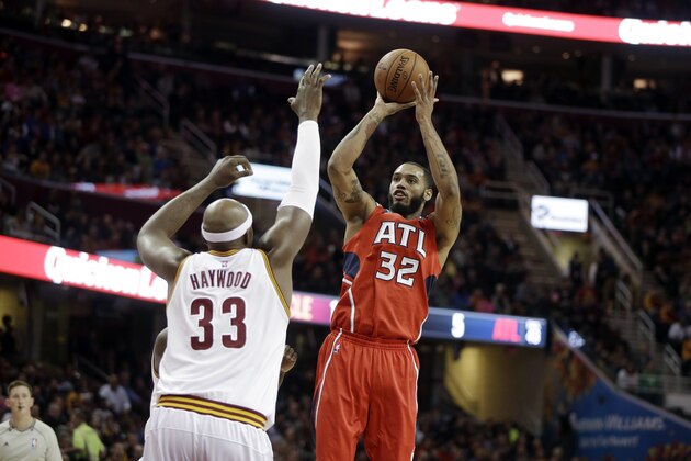 Atlanta Hawks' Mike Scott (32) shoots over Cleveland Cavaliers' Brendan Haywood in an NBA basketball game Saturday, Nov. 15, 2014, in Cleveland. (AP Photo/Mark Duncan)