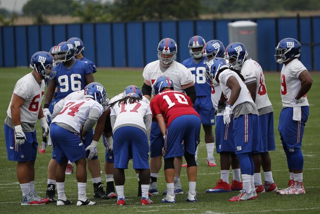 New York Giants quarterback Eli Manning (10) huddles with teammates during NFL football minicamp, Thursday, June 18, 2015, in East Rutherford, N.J. (AP Photo/Julio Cortez)