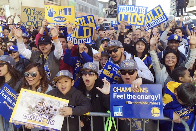 Golden State Warriors fans cheer from behind barricades as they for the NBA basketball team's world championship parade in Oakland, Calif. Friday, June 19, 2015. in a rare moment of glory, Oakland will shine in the national spotlight as the Golden State Warriors parade through the city with their NBA championship trophy. (AP Photo/ Jeff Chiu)