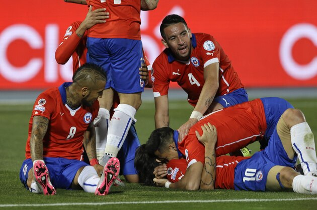 Chile's Alexis Sanchez, center right, top, embraces a teammate as he celebrates his goal against Bolivia during a Copa America Group A soccer match at El Nacional stadium in Santiago, Chile, Friday, June 19, 2015. (AP Photo/Jorge Saenz)