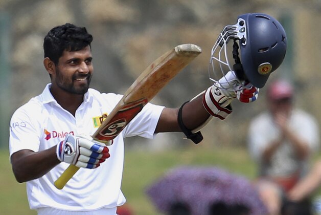Sri Lanka’s Kaushal Silva raises his bat and helmet after scoring a century during the third day of the first test cricket match against Pakistan at the Galle International Cricket Stadium in Galle, Sri Lanka, Friday, June 19, 2015. (AP Photo/Sanka Gayashan)