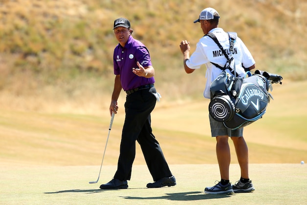 UNIVERSITY PLACE, WA - JUNE 20:  Phil Mickelson of the United States tosses his golf ball to his caddie Jim Mackay on the first green during the third round of the 115th U.S. Open Championship at Chambers Bay on June 20, 2015 in University Place, Washington.  (Photo by Andrew Redington/Getty Images)