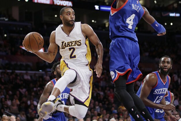 Los Angeles Lakers' Wayne Ellington, left, passes around Philadelphia 76ers' Nerlens Noel during the first half of an NBA basketball game, Sunday, March 22, 2015, in Los Angeles. (AP Photo/Jae C. Hong)