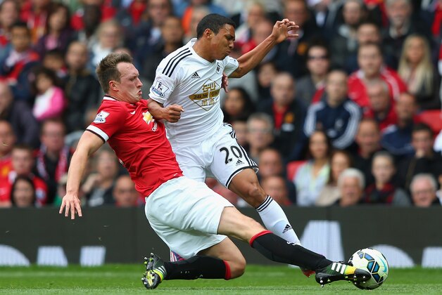 MANCHESTER, ENGLAND - AUGUST 16:  Phil Jones of Manchester United tackles Jefferson Montero of Swansea City during the Barclays Premier League match between Manchester United and Swansea City at Old Trafford on August 16, 2014 in Manchester, England.  (Photo by Alex Livesey/Getty Images)