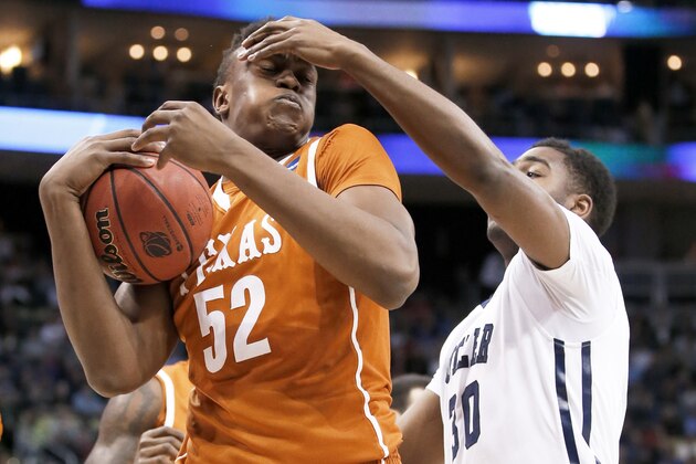 Texas's Myles Turner (52) gets a hand in the face from Texas's Ryan McClurg (30) during the second half in the second round of the NCAA college basketball tournament, Thursday, March 19, 2015, in Pittsburgh. (AP Photo/Gene J. Puskar)