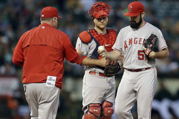Los Angeles Angels pitcher Matt Shoemaker, right, hands the ball to manager Mike Scioscia after being removed in the fifth inning of a baseball game against the Oakland Athletics Friday, June 19, 2015, in Oakland, Calif. (AP Photo/Ben Margot)