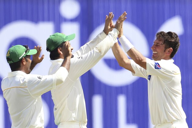Pakistan's Yasir Shah,right, celebrates the dismissal of Sri Lanka's Rangana Herath during the final day of their first test cricket match in Galle, Sri Lanka, Sunday, June 21, 2015. Leg-spinner Yasir Shah took career-best figures of seven for 76 to help Pakistan to a convincing ten wicket win over Sri Lanka on Sunday. (AP Photo/Sanka Gayashan)