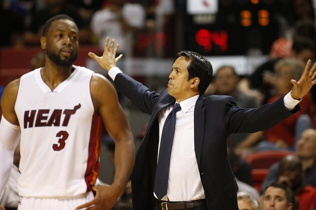 Miami Heat's Dwyane Wade (3) walks back onto the court as Erik Spoelstra calls a play during the second half of an NBA basketball game against the Orlando Magic, Monday, April 13, 2015, in Miami, Fla. Miami defeated Orlando 100-93. (AP Photo/Joel Auerbach)