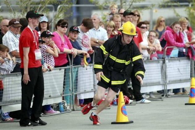 Crowds watch a firefighter compete in the Ultimate Firefighter contest during the World Police and Fire Games in Belfast, Northern Ireland, Wednesday, August, 7, 2013.  (AP Photo/Peter Morrison)