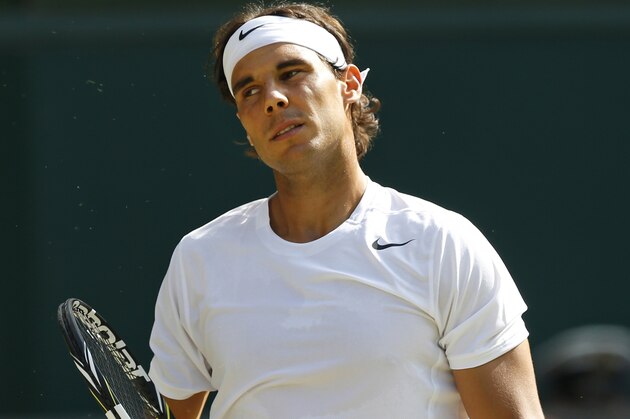 FILE - In this July 1, 2014 file photo, Rafael Nadal of Spain loses a point to Nick Kyrgios of Australia during their men's singles match at the All England Lawn Tennis Championships in Wimbledon, London. Nadal is withdrawing from hard-court tournaments in Toronto and Cincinnati because of a right wrist injury, putting his status in doubt for a title defense at the U.S. Open. His manager announced the withdrawals Wednesday, July 30, 2014. (AP Photo/Ben Curtis, File)