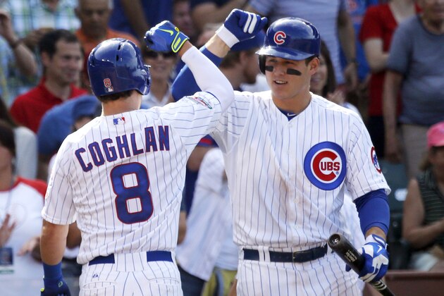 Chicago Cubs' Chris Coghlan (8) celebrates his home run off Pittsburgh Pirates starting pitcher Charlie Morton with Anthony Rizzo, outside the dugout, during the fifth inning of a baseball game Friday, June 20, 2014, in Chicago. (AP Photo/Charles Rex Arbogast)