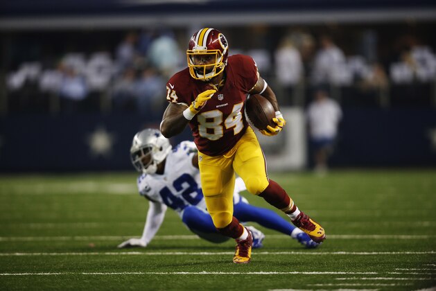 Washington Redskins tight end Niles Paul (84) escapes the grasp of Dallas Cowboys free safety Barry Church (42) during the first half of an NFL football game, Monday, Oct. 27, 2014, in Arlington, Texas. (AP Photo/Tim Sharp)