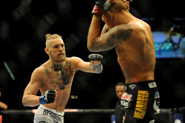 Sep 27, 2014; Las Vegas, NV, USA; Conor McGregor (blue gloves) fights Dustin Poirier (red gloves) during a featherweight fight during UFC 178 at MGM Grand Garden Arena. Mandatory Credit: Stephen R. Sylvanie-USA TODAY Sports