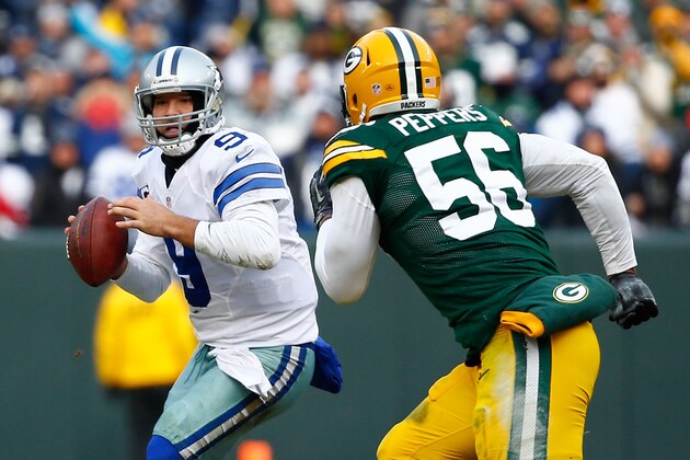 GREEN BAY, WI - JANUARY 11:   Tony Romo #9 of the Dallas Cowboys looks to pass against Julius Peppers #56 of the Green Bay Packers during the 2015 NFC Divisional Playoff game at Lambeau Field on January 11, 2015 in Green Bay, Wisconsin.  (Photo by Al Bello/Getty Images)