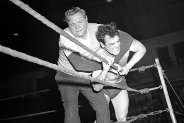 Babe Ruth, left, 240 pounds, applies his own version of a neck lock to Manuel Cortez, 200, after the Boston grappler refused to heed the Bambino’s warnings again unnecessary roughness in about at Portlance, Maine on April 2, 1945. The Babe made his debut as wrestling referee in contest between Cortez and Leo Numa, of Seattle, Wash., the winner the Babe says he dropped four pounds chasing. (AP Photo)