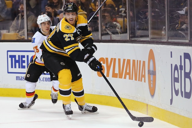 BOSTON, MA - MARCH 05:  Dougie Hamilton #27 of the Boston Bruins shields the puck from Johnny Gaudreau #13 of the Calgary Flames during overtime at TD Garden on March 5, 2015 in Boston, Massachusetts. The Flames defeat the Bruins 4-3 in a shootout.  (Photo by Maddie Meyer/Getty Images)