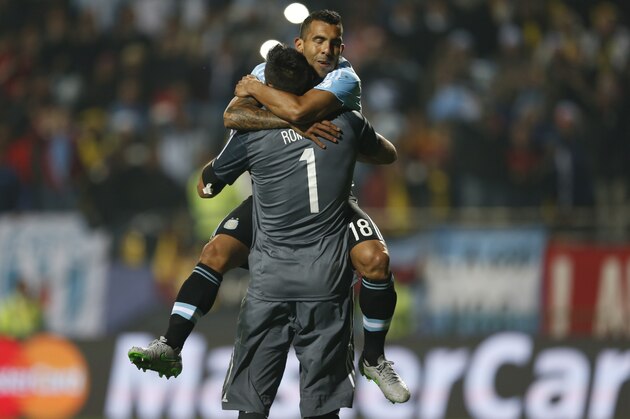Argentina's Carlos Tevez  celebrates with Argentina's goalkeeper Sergio Romero  after scoring the winning penalty kick against Colombia during a Copa America quarterfinal soccer match at the Sausalito Stadium in Vina del Mar, Chile, Friday, June 26, 2015. Argentina defeated Colombia 5-4 on penalties after a 0-0 draw on Friday to reach the semifinals of the Copa America.(AP Photo/Andre Penner)