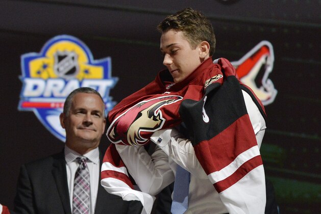 Jun 26, 2015; Sunrise, FL, USA; Dylan Strome puts on a team jersey after being selected as the number three overall pick to the Arizona Coyotes in the first round of the 2015 NHL Draft at BB&T Center. Mandatory Credit: Steve Mitchell-USA TODAY Sports