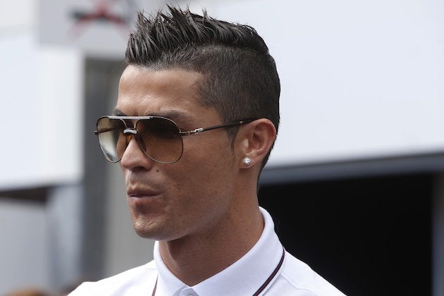 Soccer star player Cristiano Ronaldo grimaces during a photo call at the McLaren pits prior to the start of the Formula One Grand Prix, at the Monaco racetrack, in Monaco, Sunday, May 24, 2015.(AP Photo/Luca Bruno)