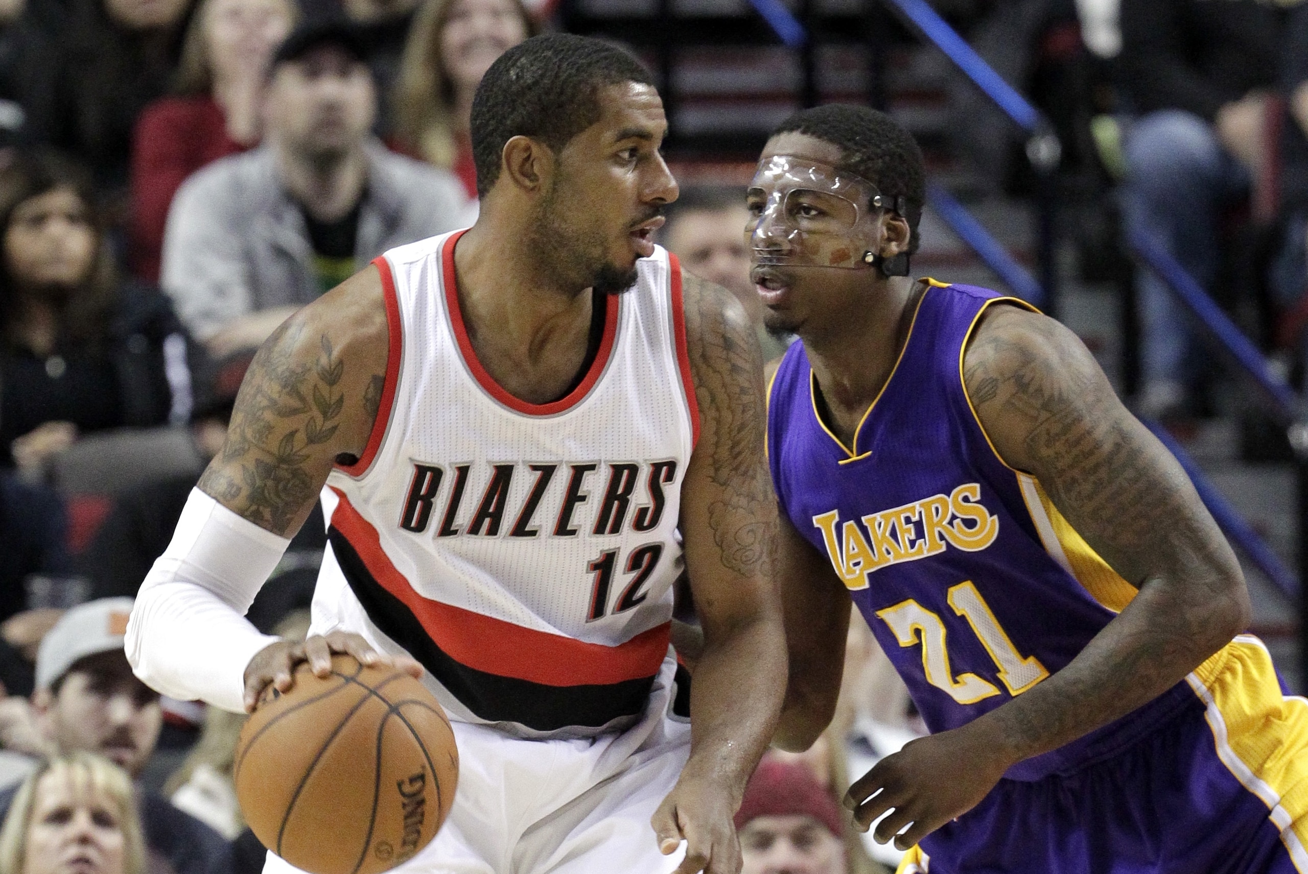 Portland Trail Blazers forward LaMarcus Aldridge, left, works the ball in against Los Angeles Lakers forward Ed Davis during the first half of an NBA basketball game in Portland, Ore., Monday, Jan. 5, 2015. (AP Photo/Don Ryan)