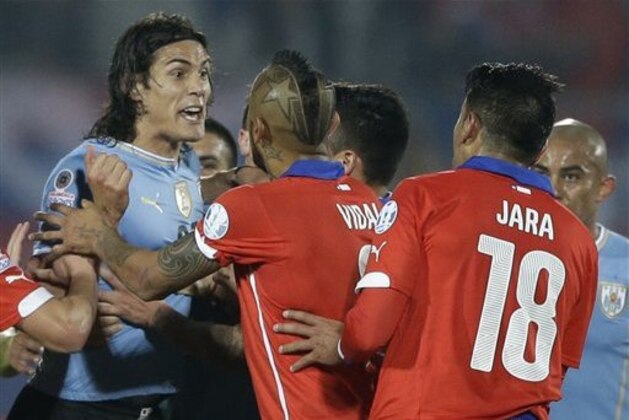 Uruguay's Edinson Cavani, left, argues with Chile's Gonzalo Jara, right, during a Copa America quarterfinal soccer match at the National Stadium in Santiago, Chile, Wednesday, June 24, 2015. South American football officials will look into the actions of Jara, who was caught by TV cameras poking Cavani's behind to provoke a red card, which could lead to a suspension for the Chilean player. Cavani, Uruguay's top striker in the South American tournament, was sent off after the provocation by Jara, and Chile went on to win 1-0. (AP Photo/Ricardo Mazalan)