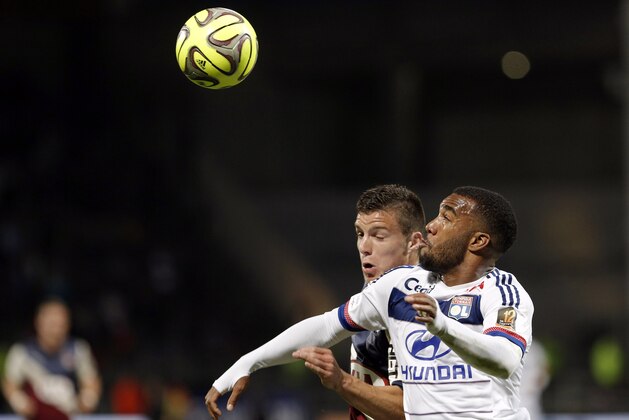 Lyon's Alexandre Lacazette, right, challenges for the ball with Bordeaux' Frederic Guilbert,  during the French League One soccer match between Lyon and Bordeaux, in Lyon, central France, Saturday, May 16, 2015. (AP Photo/Laurent Cipriani)