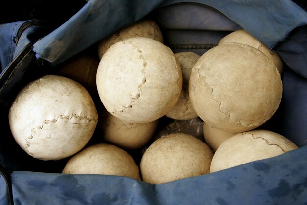 ** ADVANCE FOR WEEKEND EDITIONS OCT. 15-16  ** A bag of 16-inch softballs is seen on the field before a matchup before a high school game  in Chicago, Sept. 28, 2005. Chicago's unique brand of the game that's played with 16-inch balls and without mitts may be following the steel mills into the history books and enthusiasts are hoping that teenagers can keep the sport alive. Six years after 16-inch softball was introduced as a varsity sport in the Chicago Public Schools, the number of schools with teams has doubled from 25 to 50 and expected to increase next year. (AP Photo/Nam Y. Huh)
