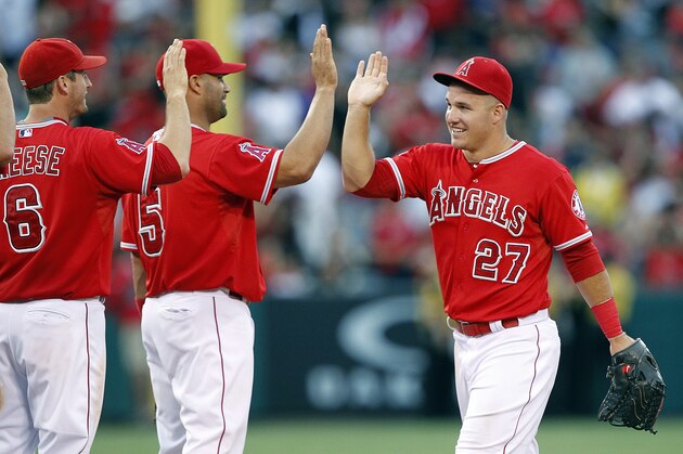 Los Angeles Angels third baseman David Freese, left, and first baseman Albert Pujols, center, congratulate center fielder Mike Trout after the Angels defeated the Seattle Mariners 4-2 in a baseball game in Anaheim, Calif., Saturday, June 27, 2015. (AP Photo/Alex Gallardo)