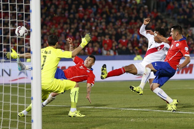 Chile's Gary Medel, second left, scores an own goal past Chile's goalkeeper Claudio Bravo, left, under pressure from Peru's Andre Carrillo, second right, during a Copa America semifinal soccer match at the National Stadium in Santiago, Chile, Monday, June 29, 2015. (AP Photo/Andre Penner)