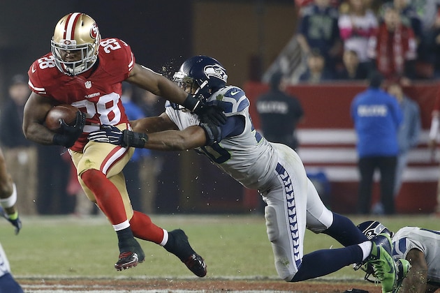 San Francisco 49ers running back Carlos Hyde (28) runs against Seattle Seahawks outside linebacker K.J. Wright during the third quarter of an NFL football game in Santa Clara, Calif., Thursday, Nov. 27, 2014. (AP Photo/Tony Avelar)