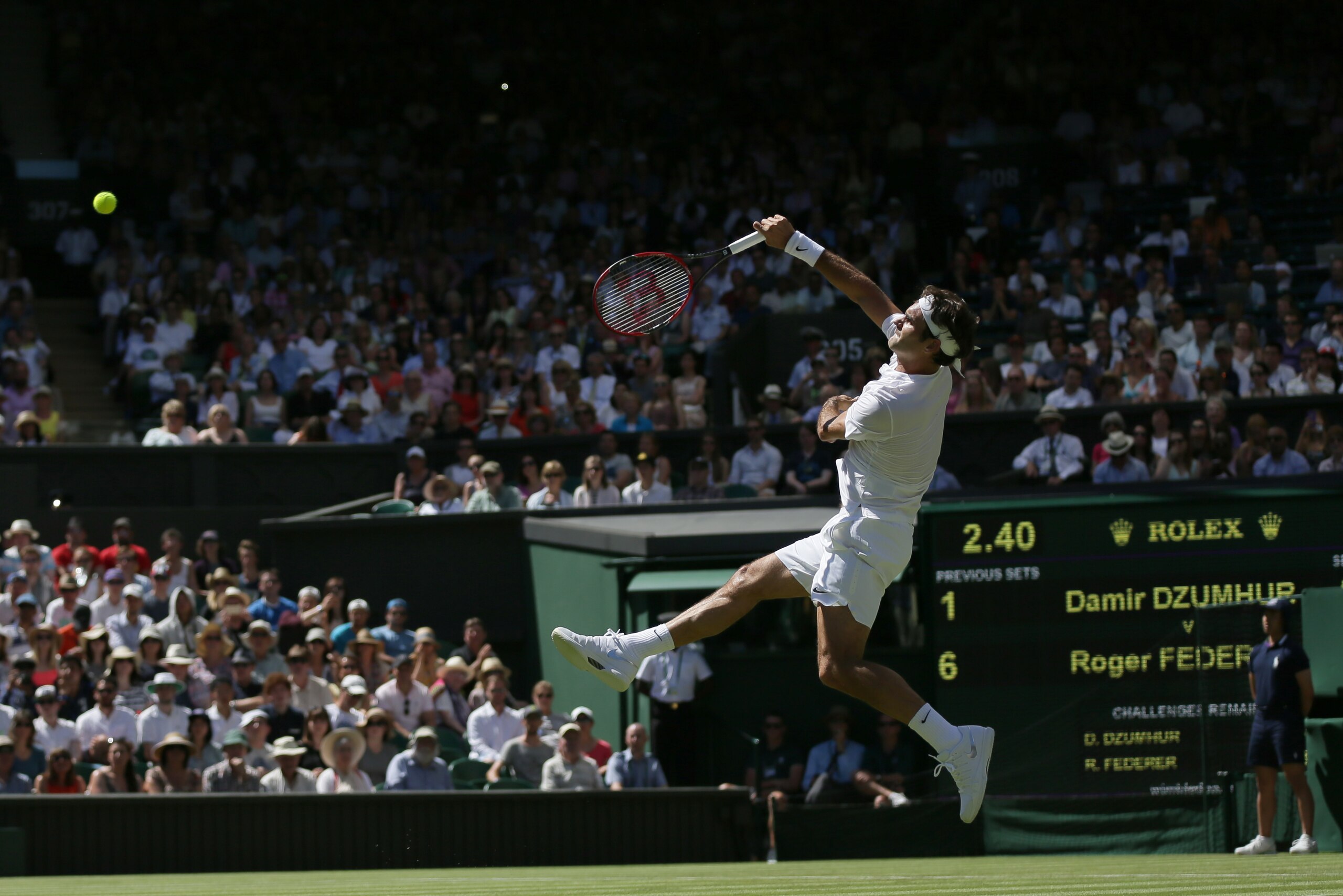 Roger Federer of Switzerland smashes a ball to Damir Dzumhur of Bosnia during the singles first round match at the All England Lawn Tennis Championships in Wimbledon, London, Tuesday June 30, 2015. (AP Photo/Tim Ireland)