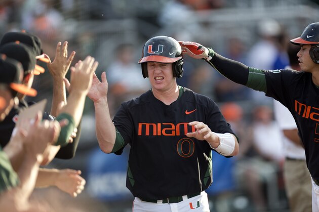 Miami's Zack Collins (0) celebrates after scoring a run against FIU during the first inning of a Coral Gables Regional game of the NCAA college baseball tournament in Coral Gables, Fla., Friday, May 29, 2015. (AP Photo/J Pat Carter)