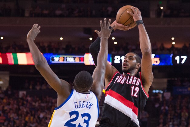 April 9, 2015; Oakland, CA, USA; Portland Trail Blazers forward LaMarcus Aldridge (12) shoots the basketball against Golden State Warriors forward Draymond Green (23) during the first quarter at Oracle Arena. The Warriors defeated the Trail Blazers 116-105. Mandatory Credit: Kyle Terada-USA TODAY Sports