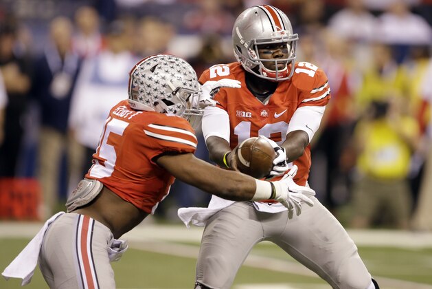 Ohio State quarterback Cardale Jones, right, hands off to running back Ezekiel Elliott as Elliott carries the ball for an 81-yard touchdown run during the first half of the Big Ten Conference championship NCAA college football game against Wisconsin Saturday, Dec. 6, 2014, in Indianapolis. (AP Photo/Darron Cummings)