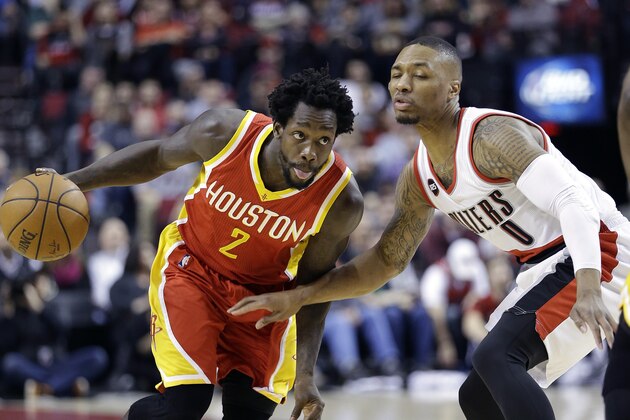 Houston Rockets guard Patrick Beverley, left, drives on Portland Trail Blazers guard Damian Lillard during the first half of an NBA basketball game in Portland, Ore., Wednesday, March 11, 2015. (AP Photo/Don Ryan)