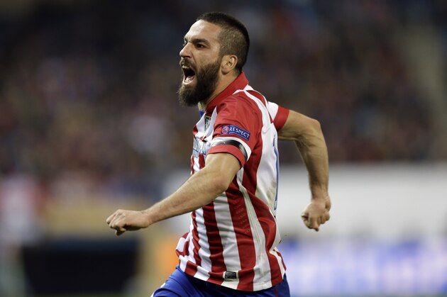 Atletico's Arda Turan celebrates scoring his side's second goal during a Champions League, round of 16, second leg, soccer match between Atletico Madrid and AC Milan at the Vicente Calderon stadium in Madrid, Tuesday March 11, 2014. (AP Photo/Paul White)