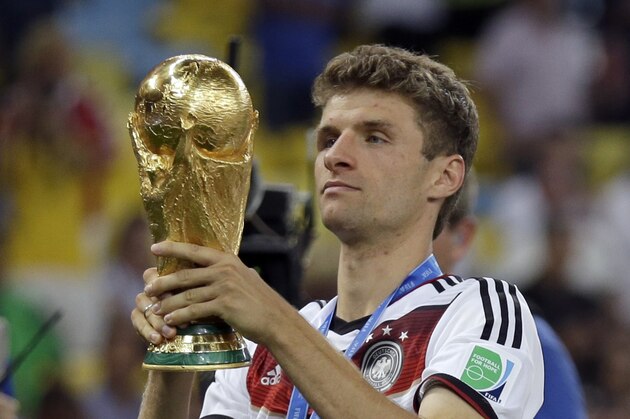 Germany's Thomas Mueller examines the World Cup trophy following their 1-0 victory over Argentina after the World Cup final soccer match between Germany and Argentina at the Maracana Stadium in Rio de Janeiro, Brazil, Sunday, July 13, 2014. (AP Photo/Natacha Pisarenko)