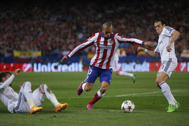 Atletico's Joao Miranda fights for the ball against Real Madrid's Sergio Ramos, left, and Gareth Bale, right, during the Champions League quarterfinal first leg soccer match between Atletico Madrid and Real Madrid at the Vicente Calderon stadium in Madrid, Spain, Tuesday, April 14, 2015. (AP Photo/Andres Kudacki)